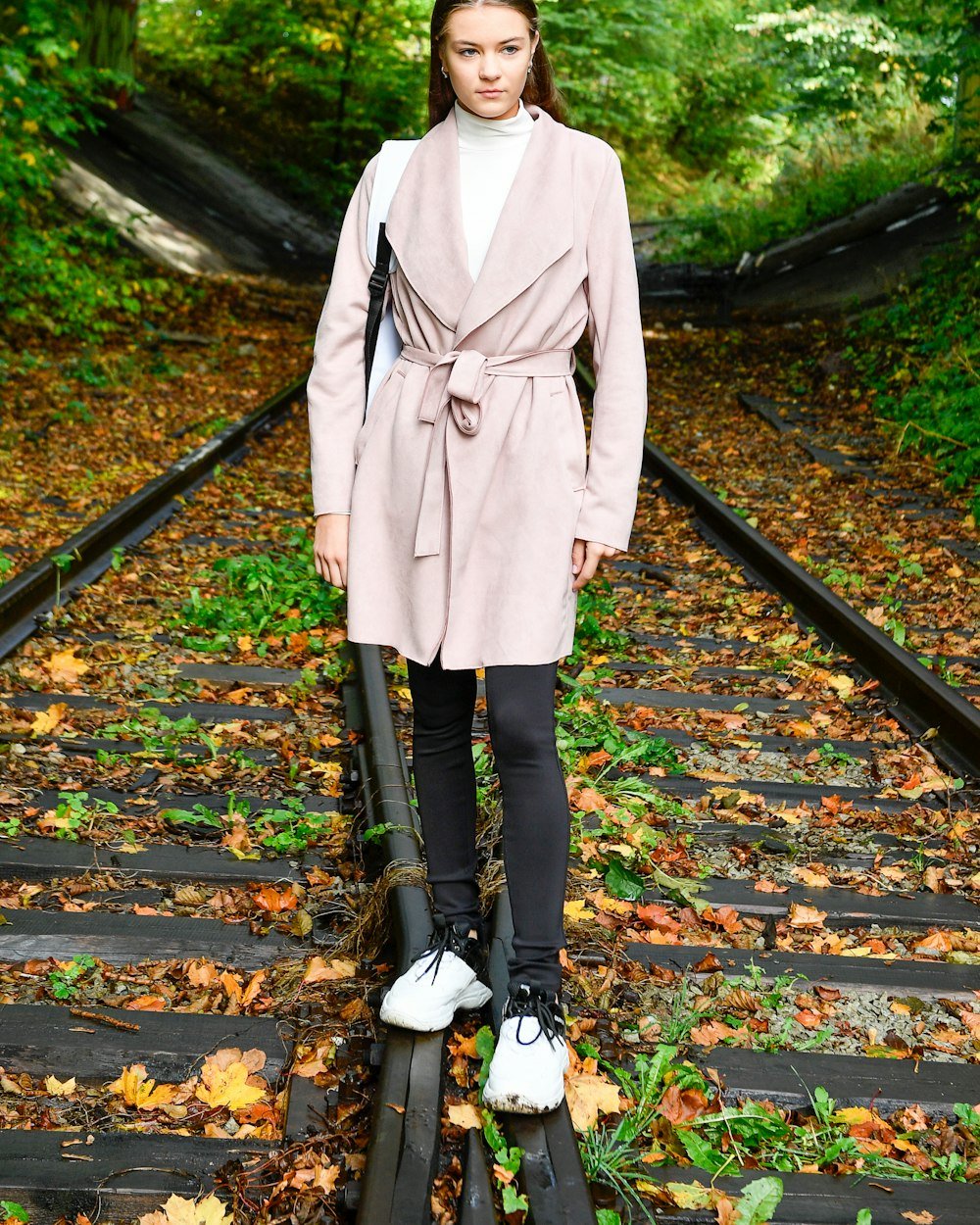 Woman standing among autumn leaves