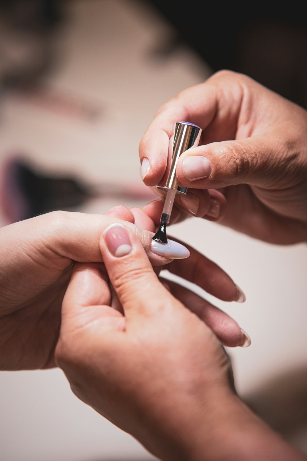 Nail polish being applied carefully to a fingernail