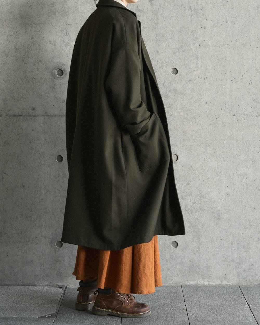 Woman in a dark coat and orange skirt
