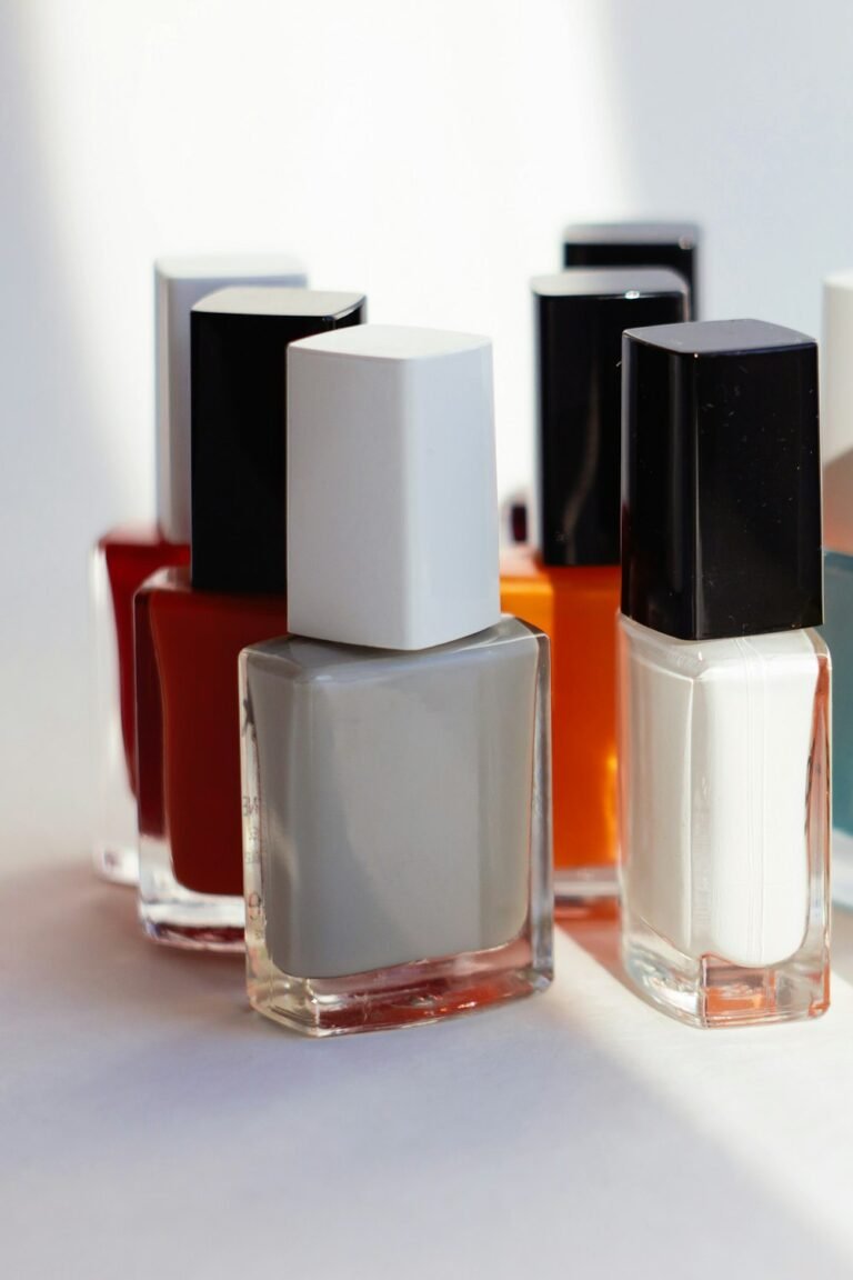 Row of pale nail polish bottles in soft daylight