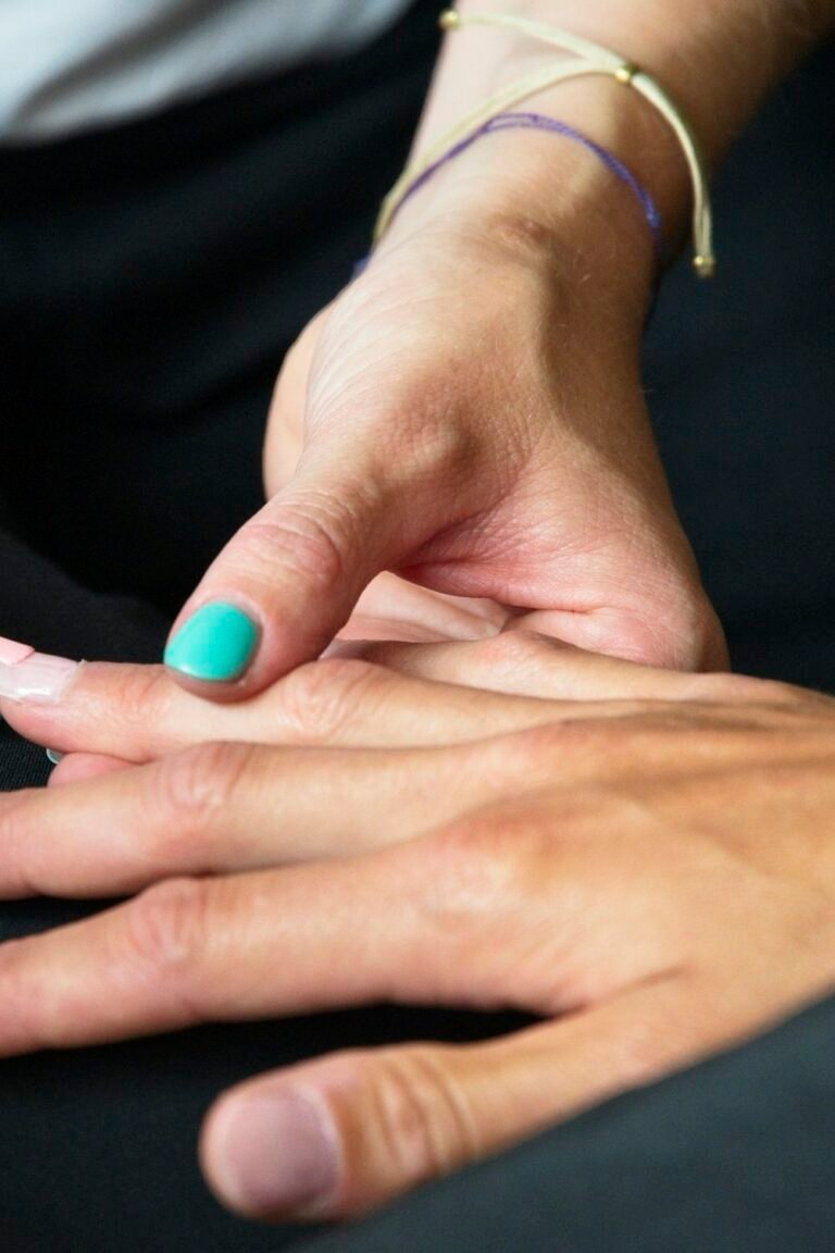 Deep plum manicure on short nails resting on a pale surface